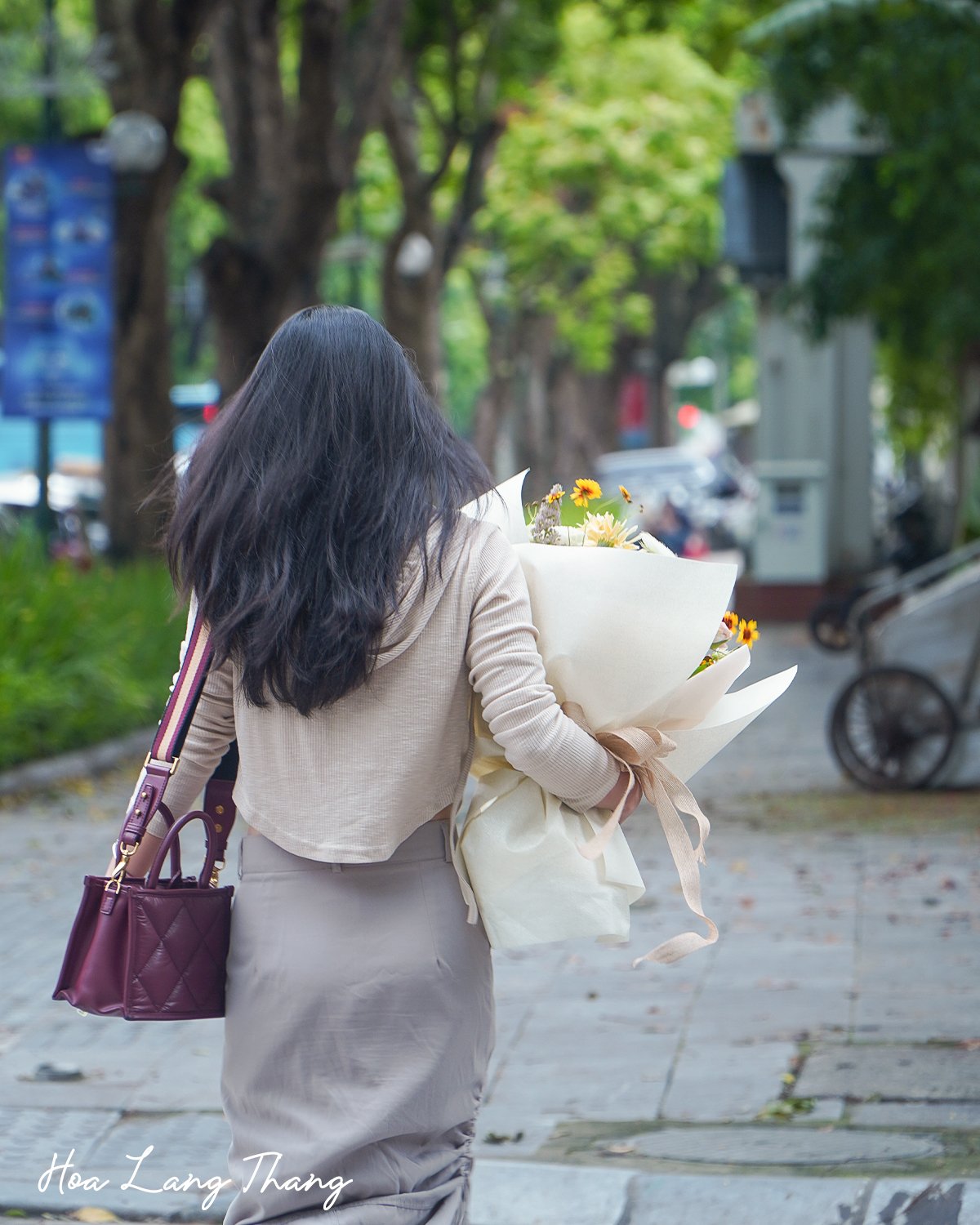 Người phụ nữ cầm bó hoa hướng dương trên phố Hà Nội