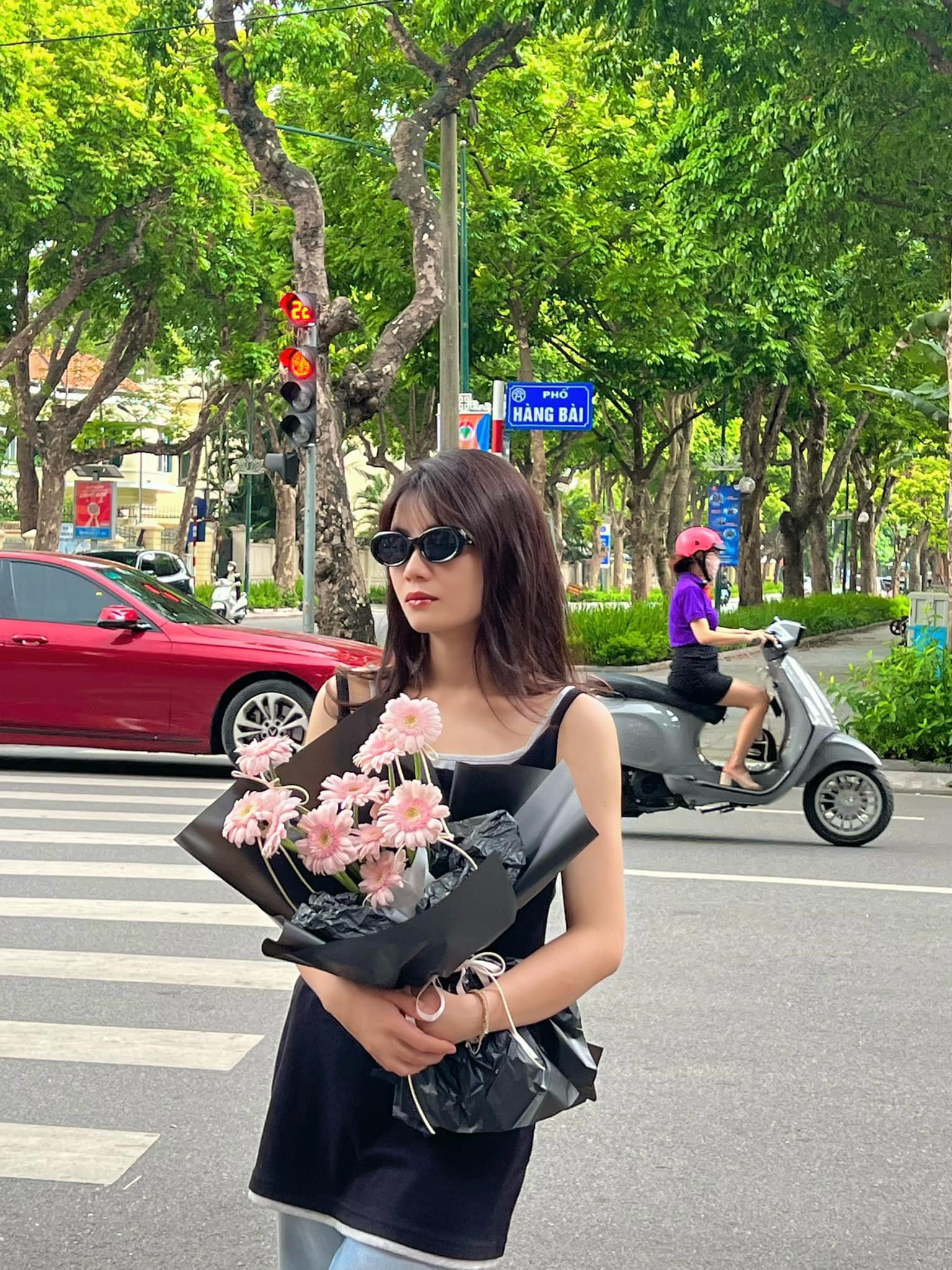Người cầm bó hoa hồng phấn trên phố Hà Nội, phong cách hiện đại