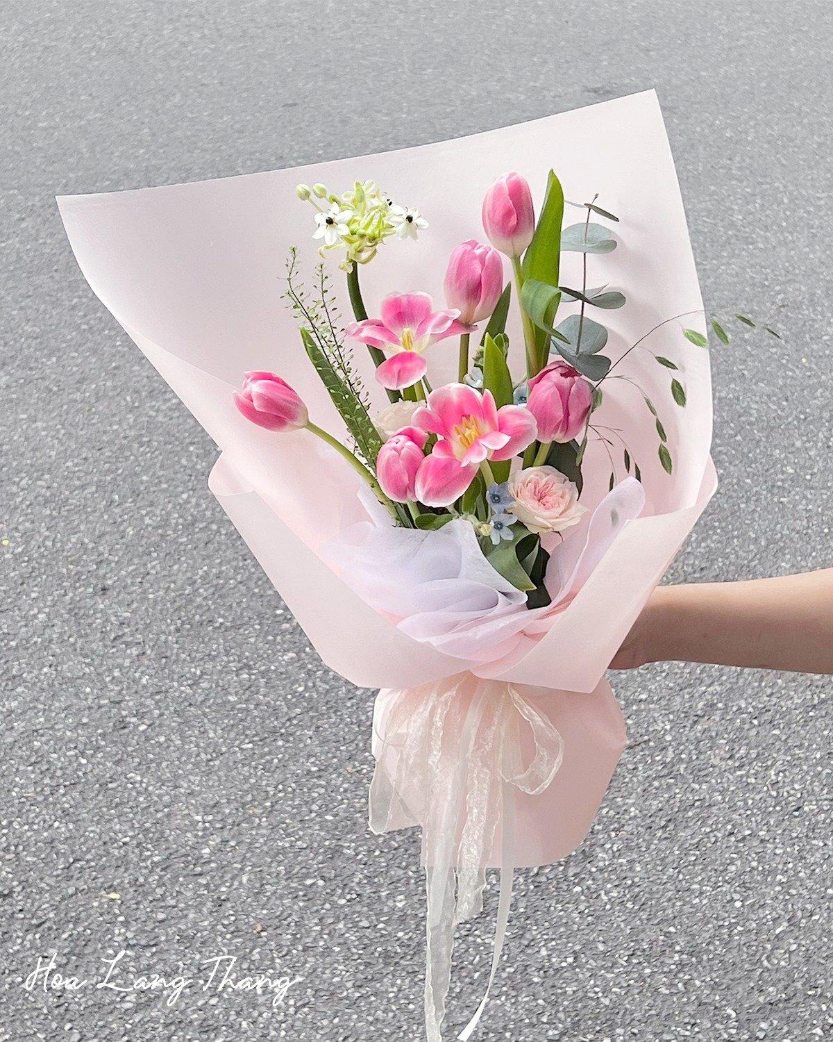 Bó hoa gồm nhiều tulip hồng và phụ liệu cắm đẹp mắt