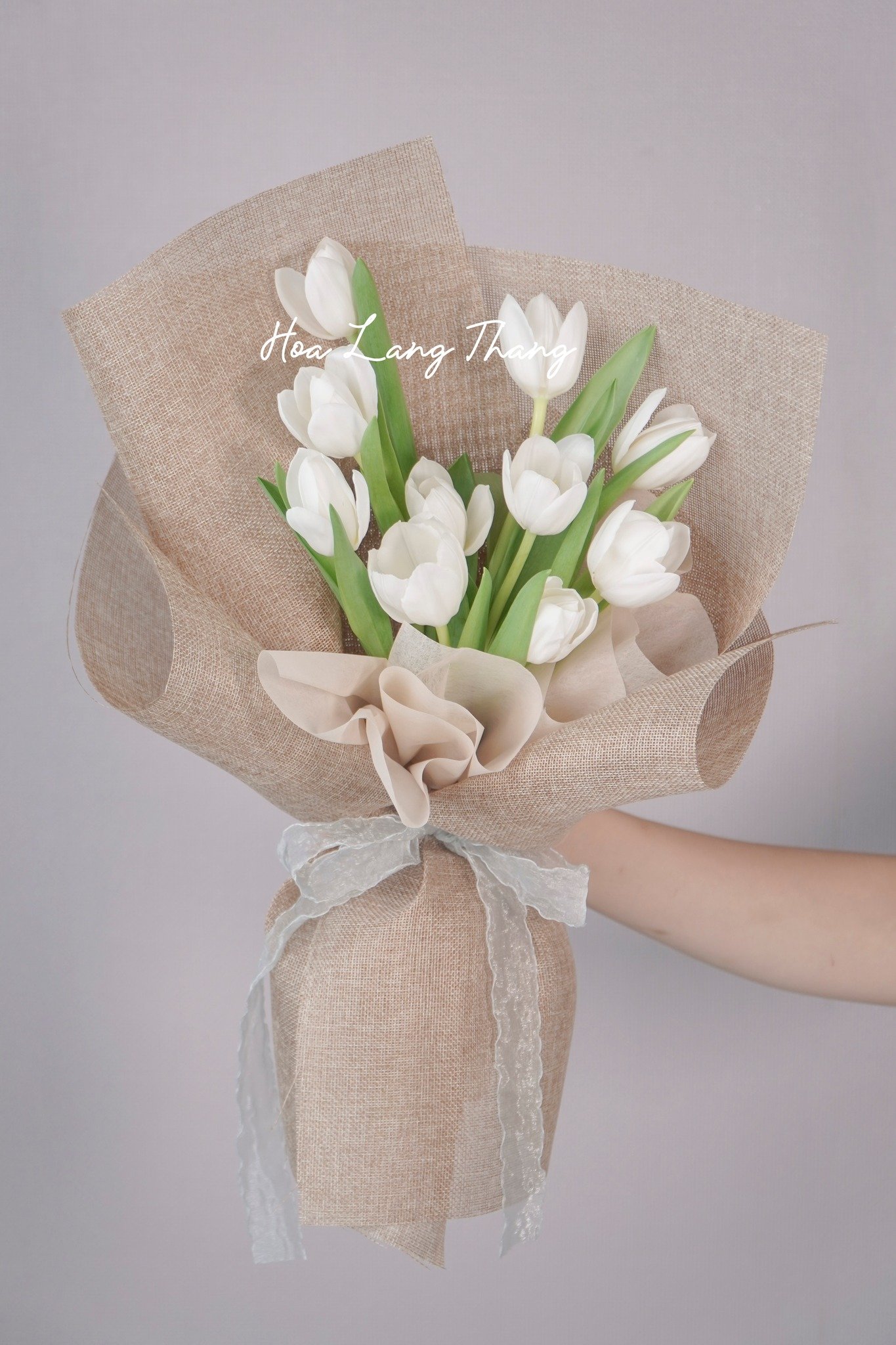 Bó hoa tulip trắng được bọc bằng vải tự nhiên tinh tế, kiểu cắm hiện đại