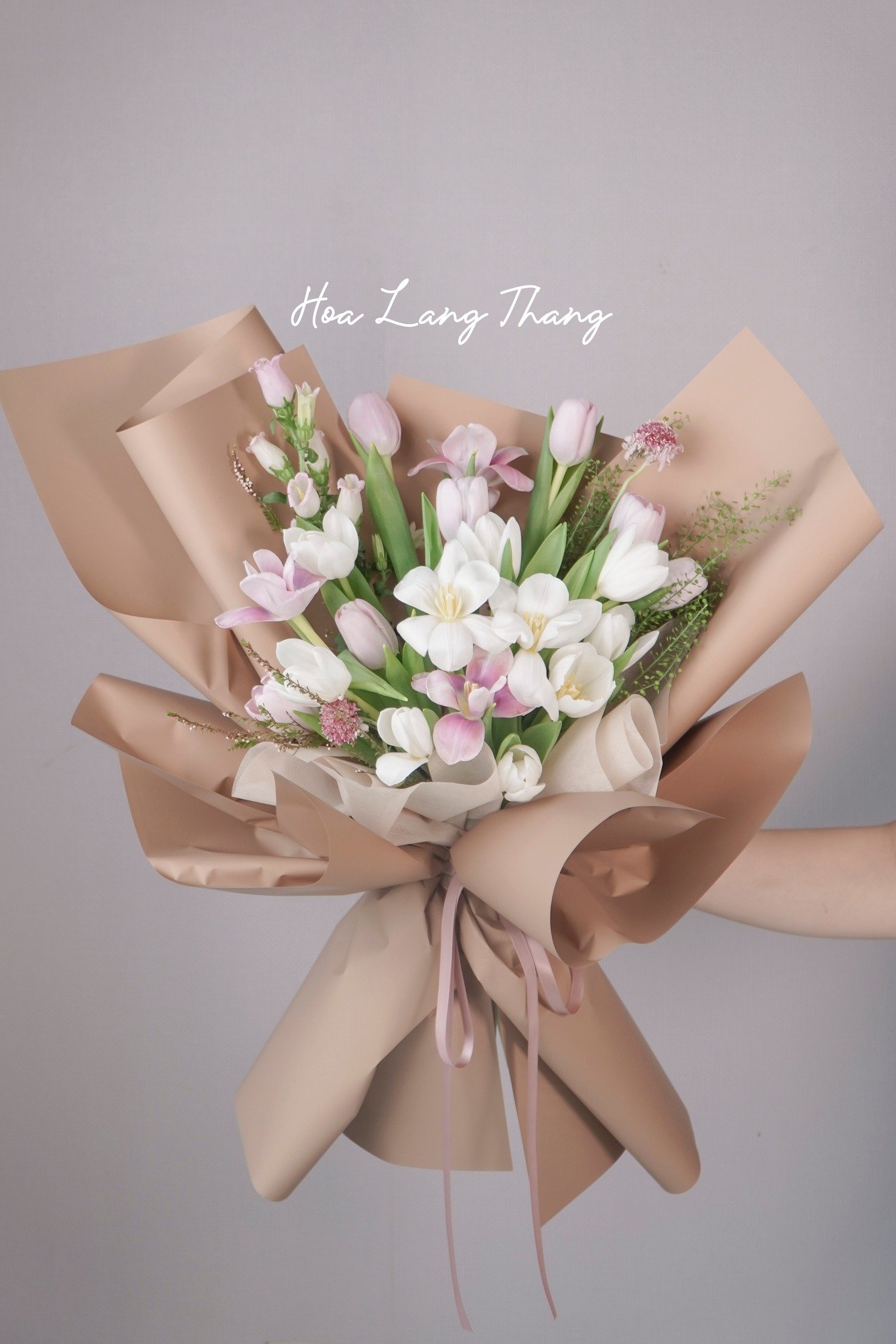 Bó hoa gồm tulip, hồng, và hoa baby được cắm trang trí tinh tế
