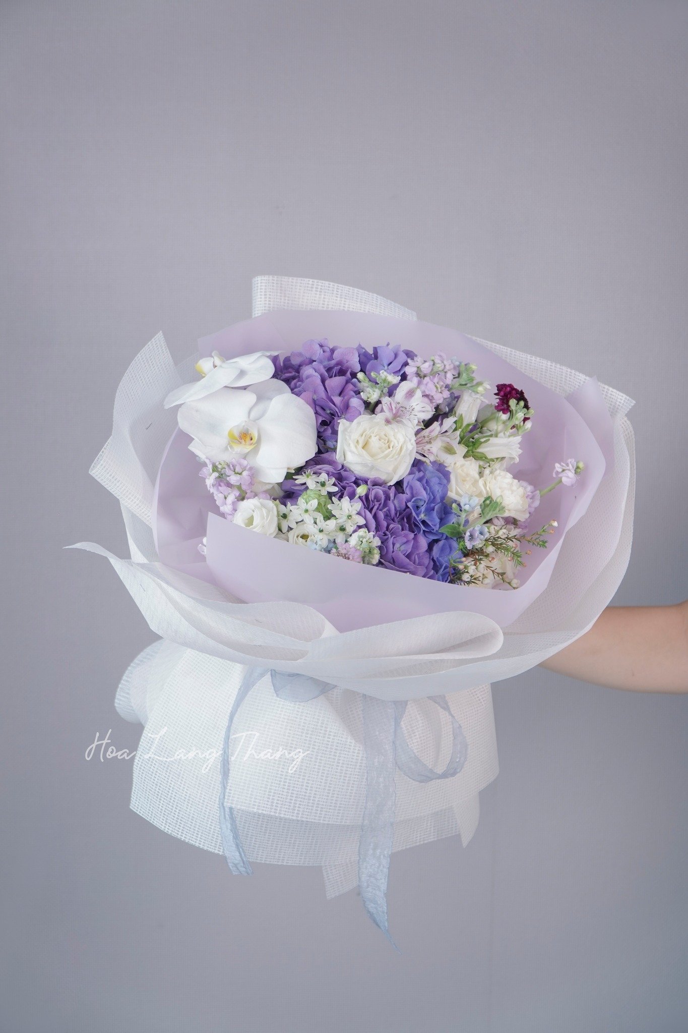 Bó hoa màu tím nhạt với hoa lan hồ điệp, hồng và cúc đẹp mắt