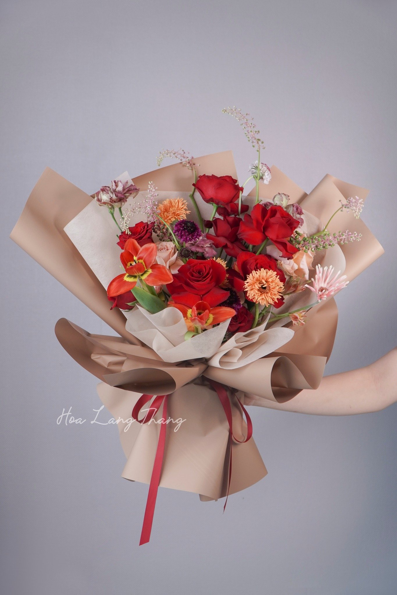 Bó hoa tươi gồm nhiều loại hoa như hồng, cúc, và lan, cắm đẹp mắt