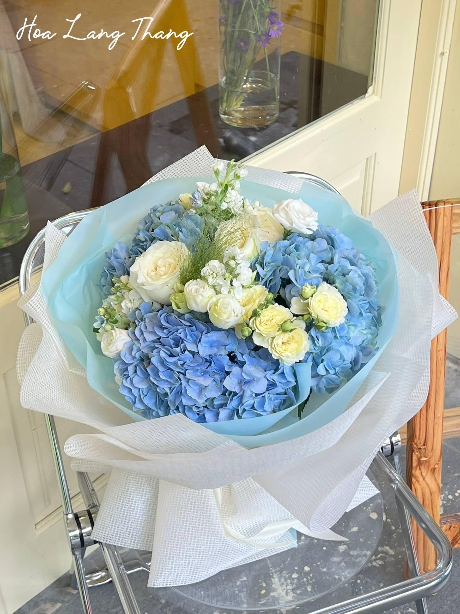 Bó hoa gồm hoa hồng, cẩm tú cầu và hoa baby màu xanh pastel