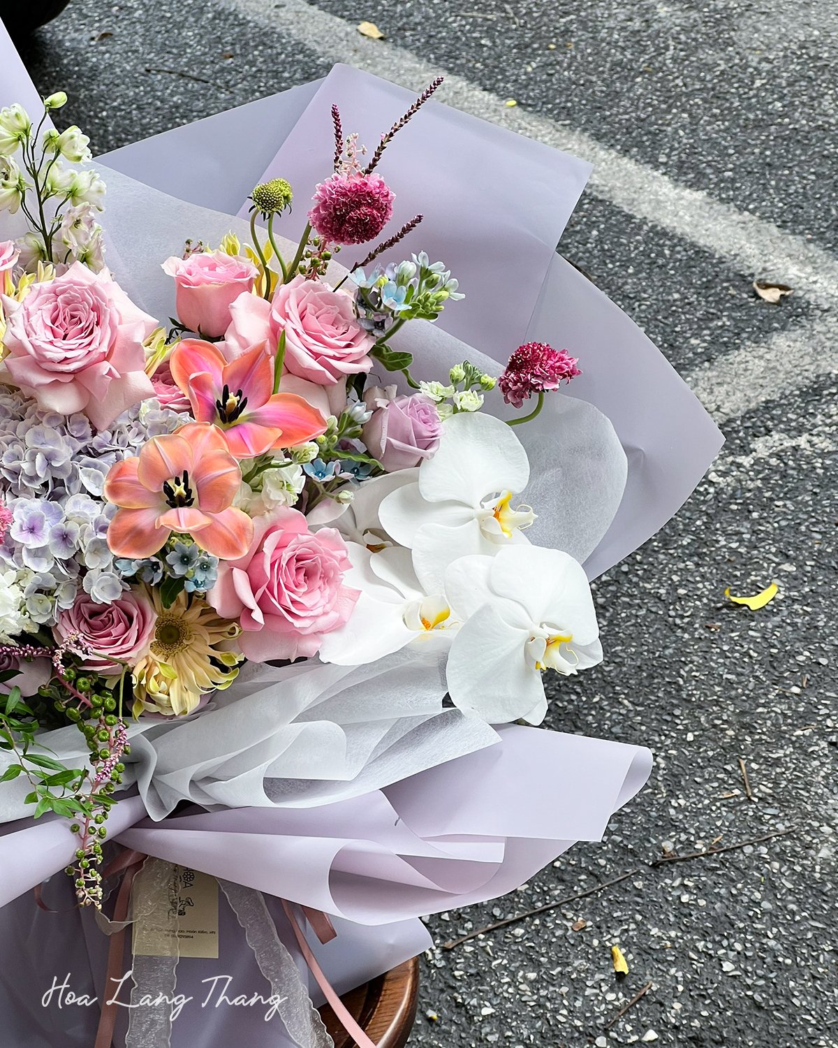 Bó hoa gồm hồng, tulip, lan hồ điệp, cắm kiểu nghệ thuật