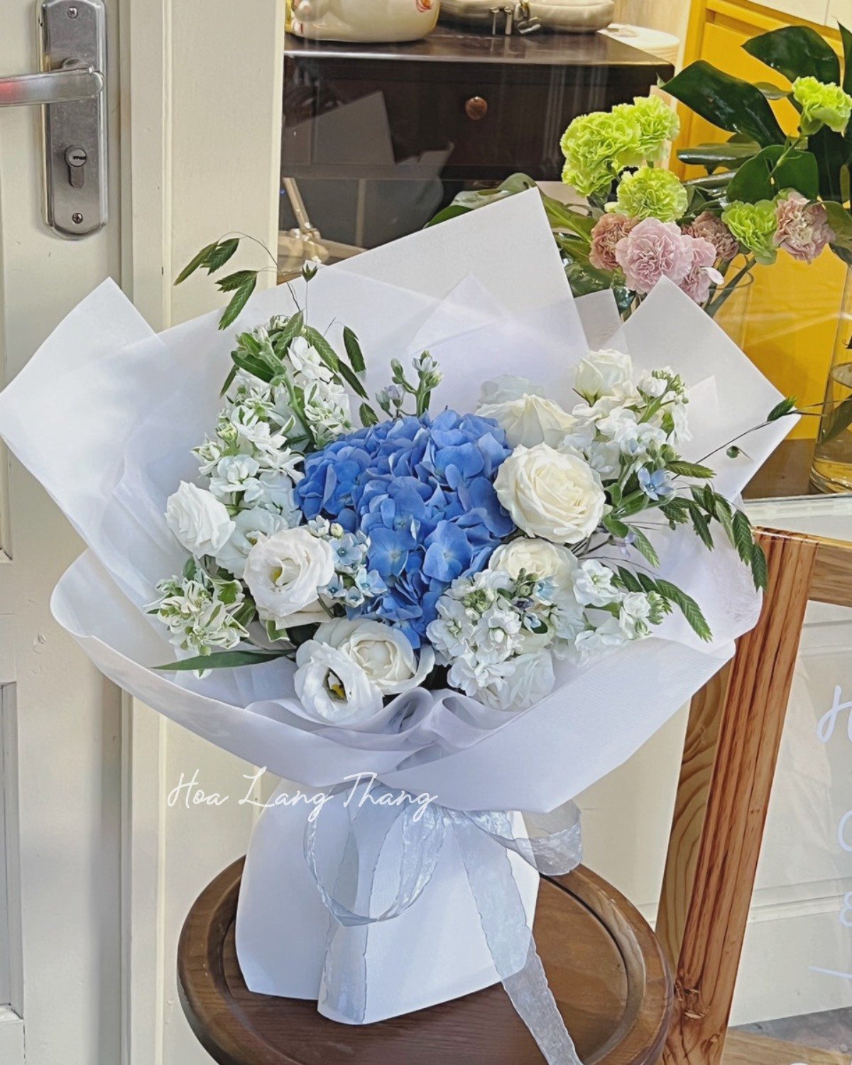 Bó hoa tươi gồm hydrangea xanh, hoa hồng trắng và hoa baby, cắm đẹp mắt