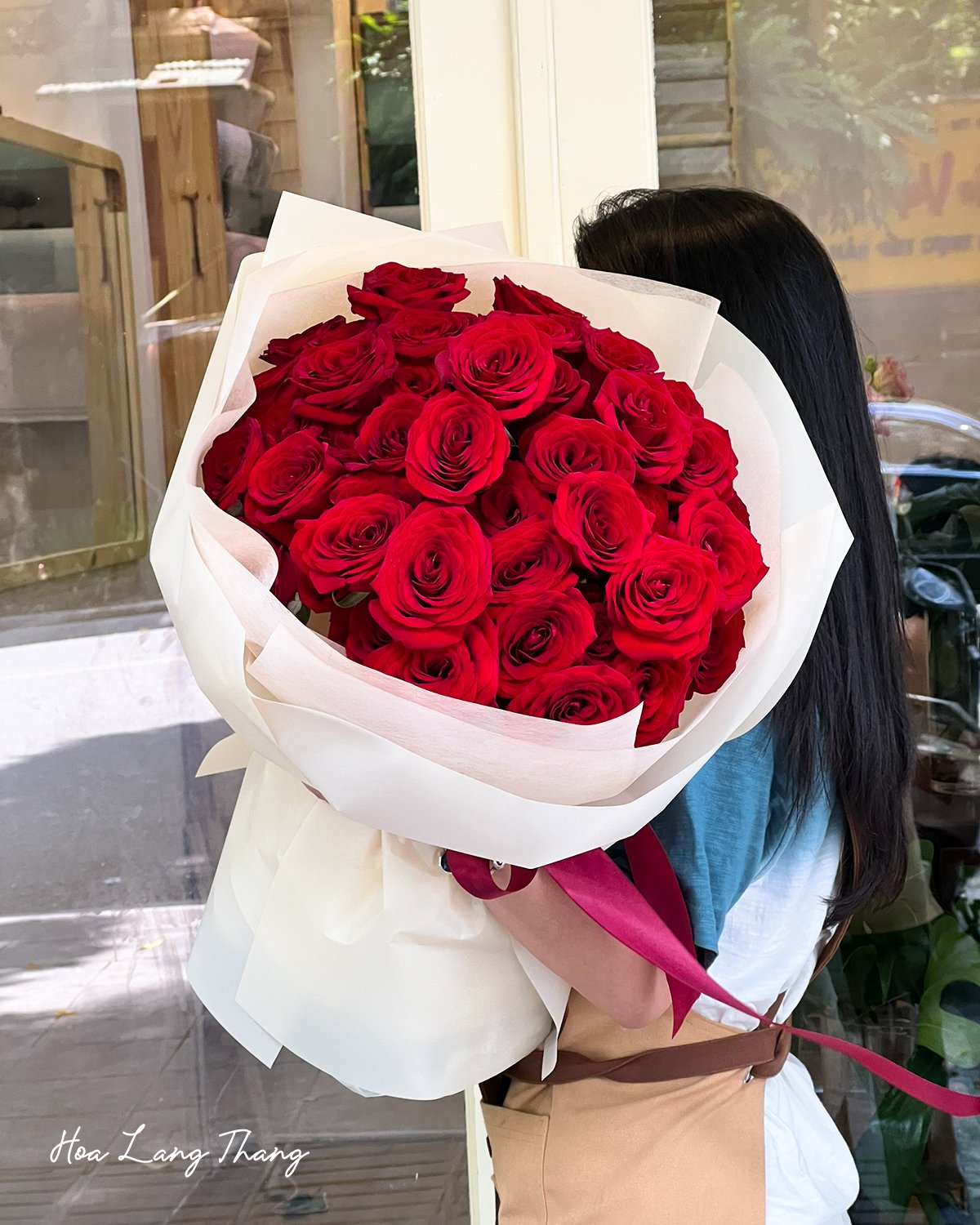 Bó hoa hồng đỏ rực rỡ trong tay, phù hợp cho nhiều dịp đặc biệt