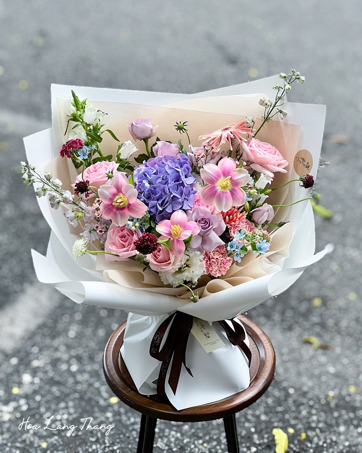Bó hoa nhiều màu sắc với tulip, hồng, và cẩm tú cầu, kiểu cắm nghệ thuật