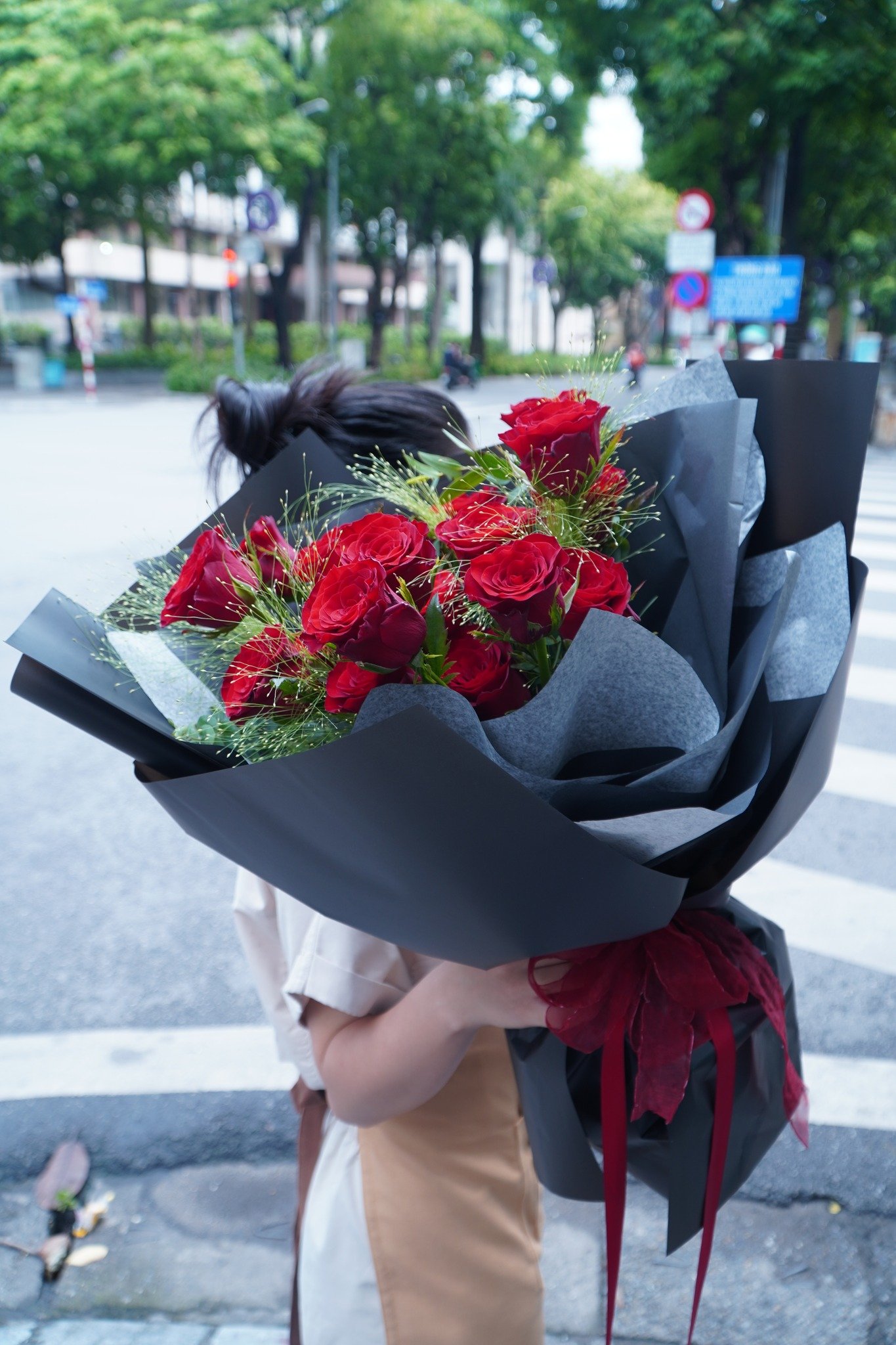 Bó hoa hồng đỏ rực rỡ kết hợp trang trí xanh tươi, đẹp mắt