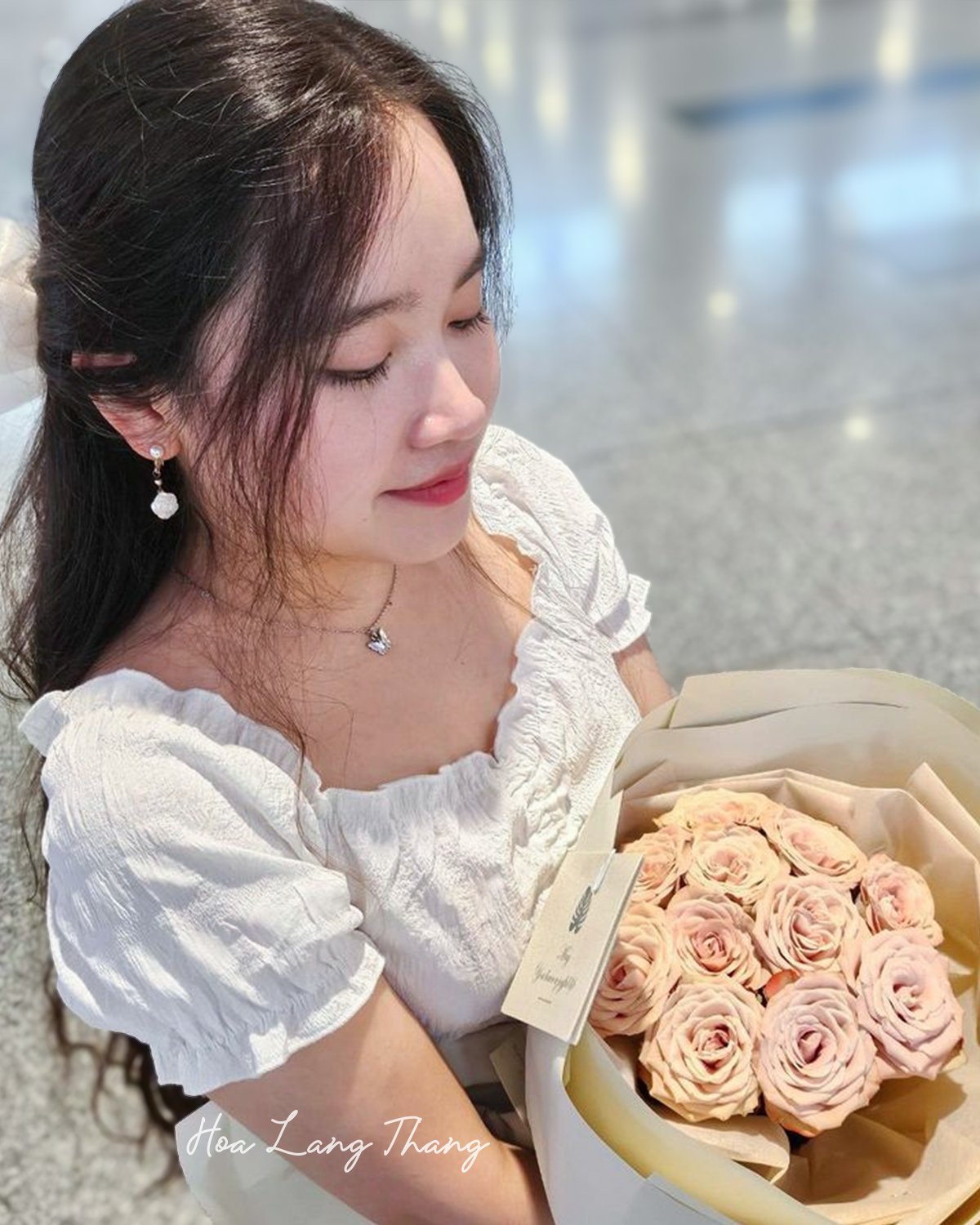 Cô gái cầm bó hoa hồng pastel xinh xắn tại shop hoa Hoa Lang Thang