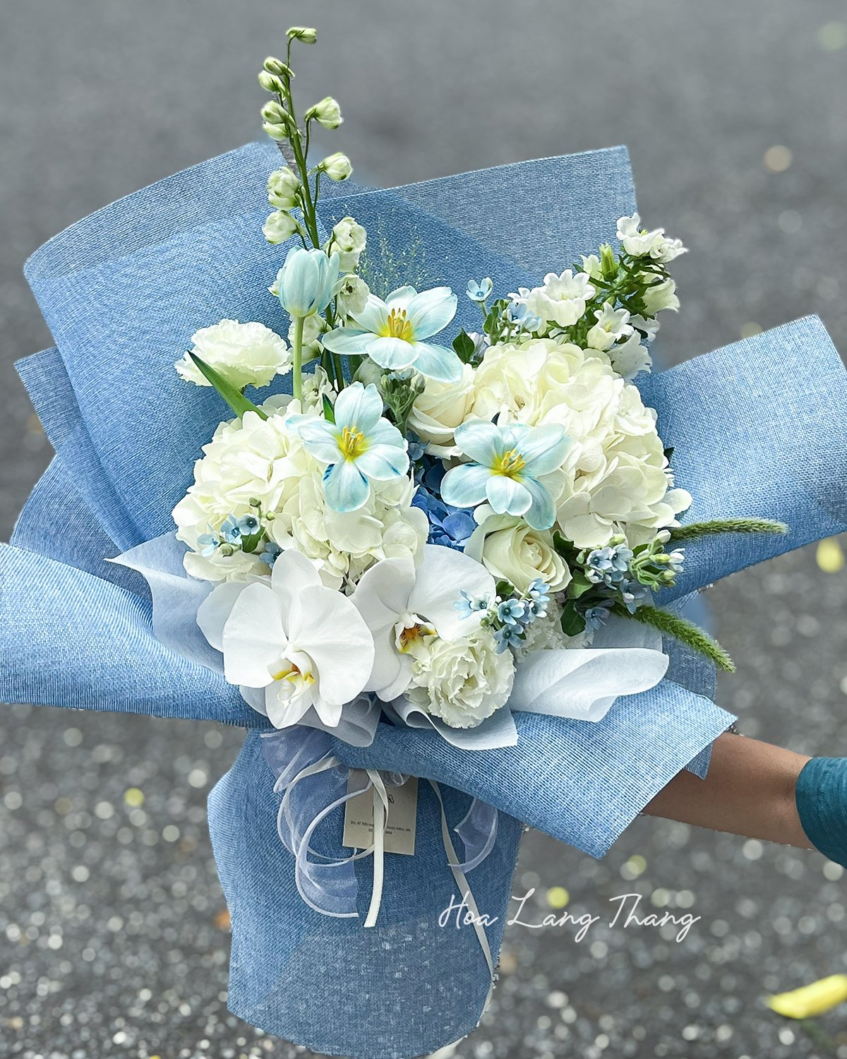 Bó hoa trắng và xanh nhẹ nhàng, gồm hồng, lan hồ điệp, mix nhiều loại hoa khác