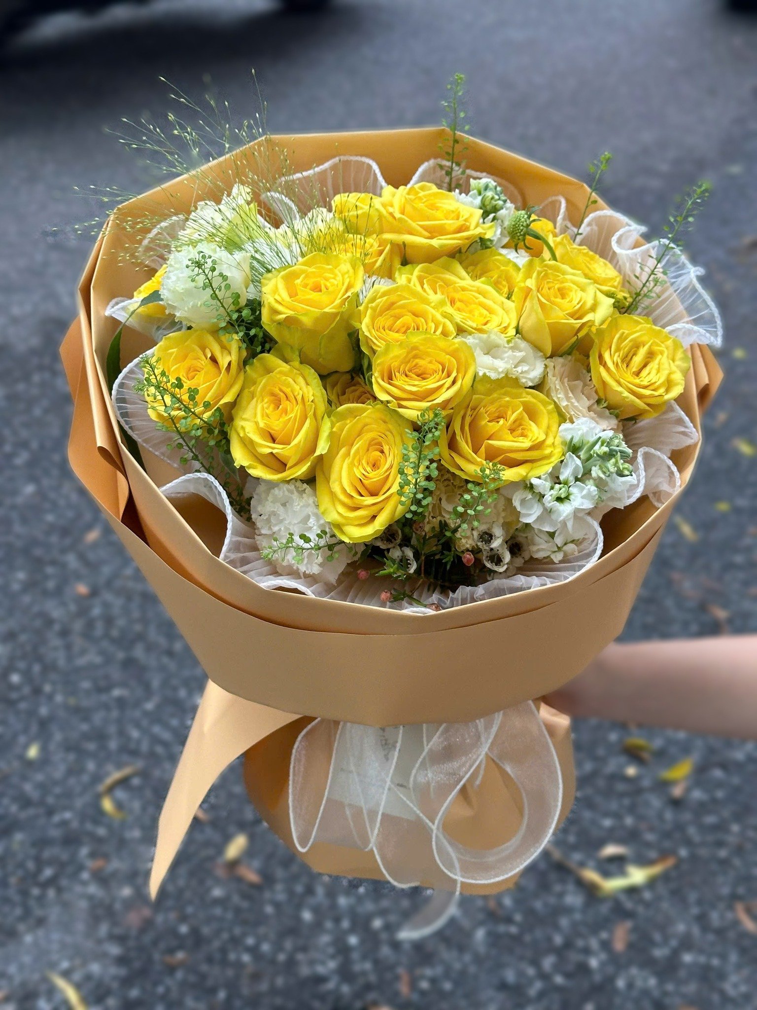 Bó hoa vàng gồm nhiều hoa hồng vàng và hoa khác, kiểu cắm lãng mạn