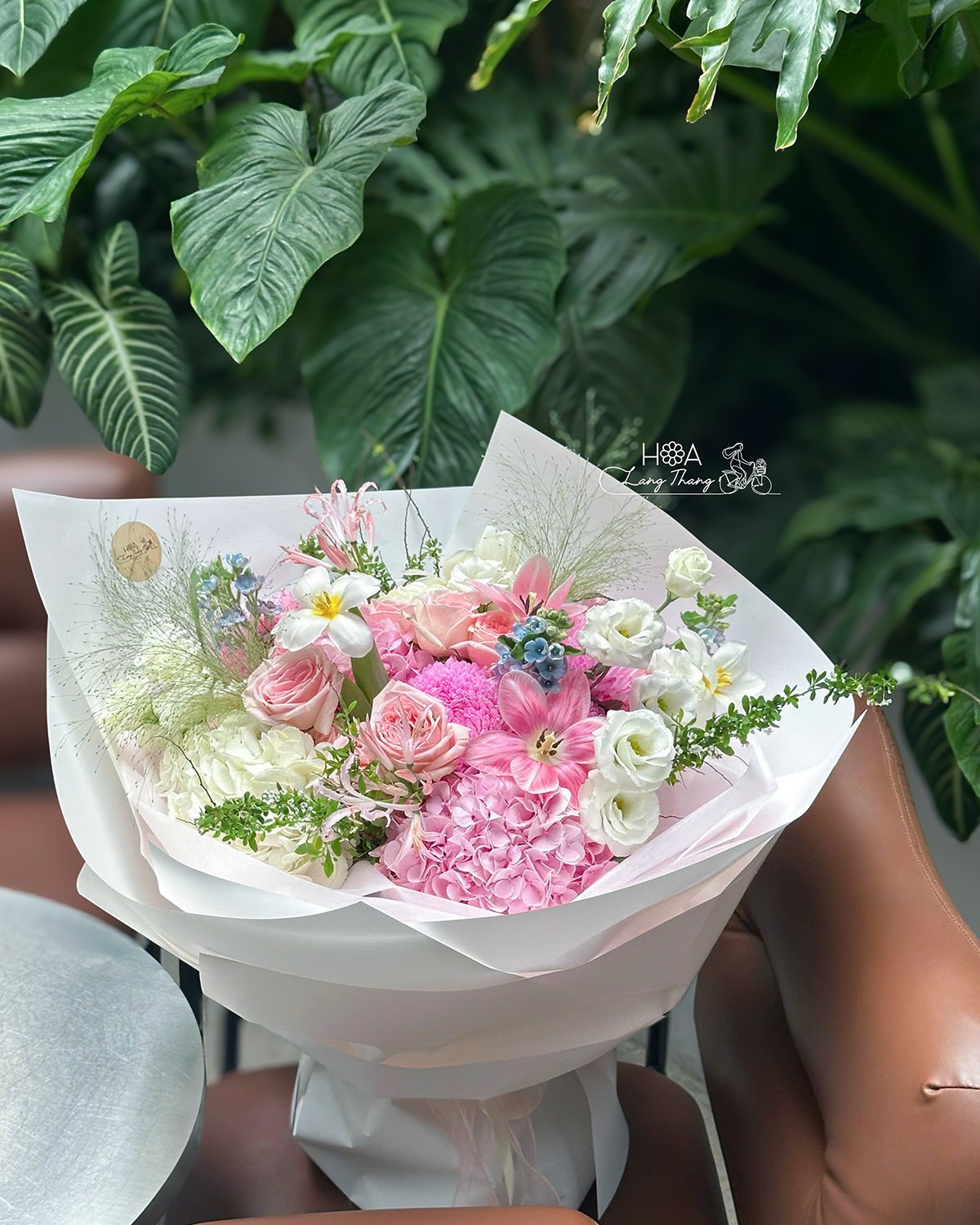 Bó hoa kết hợp hồng, cẩm tú cầu và ly, tạo thành một thiết kế tinh tế và dịu dàng
