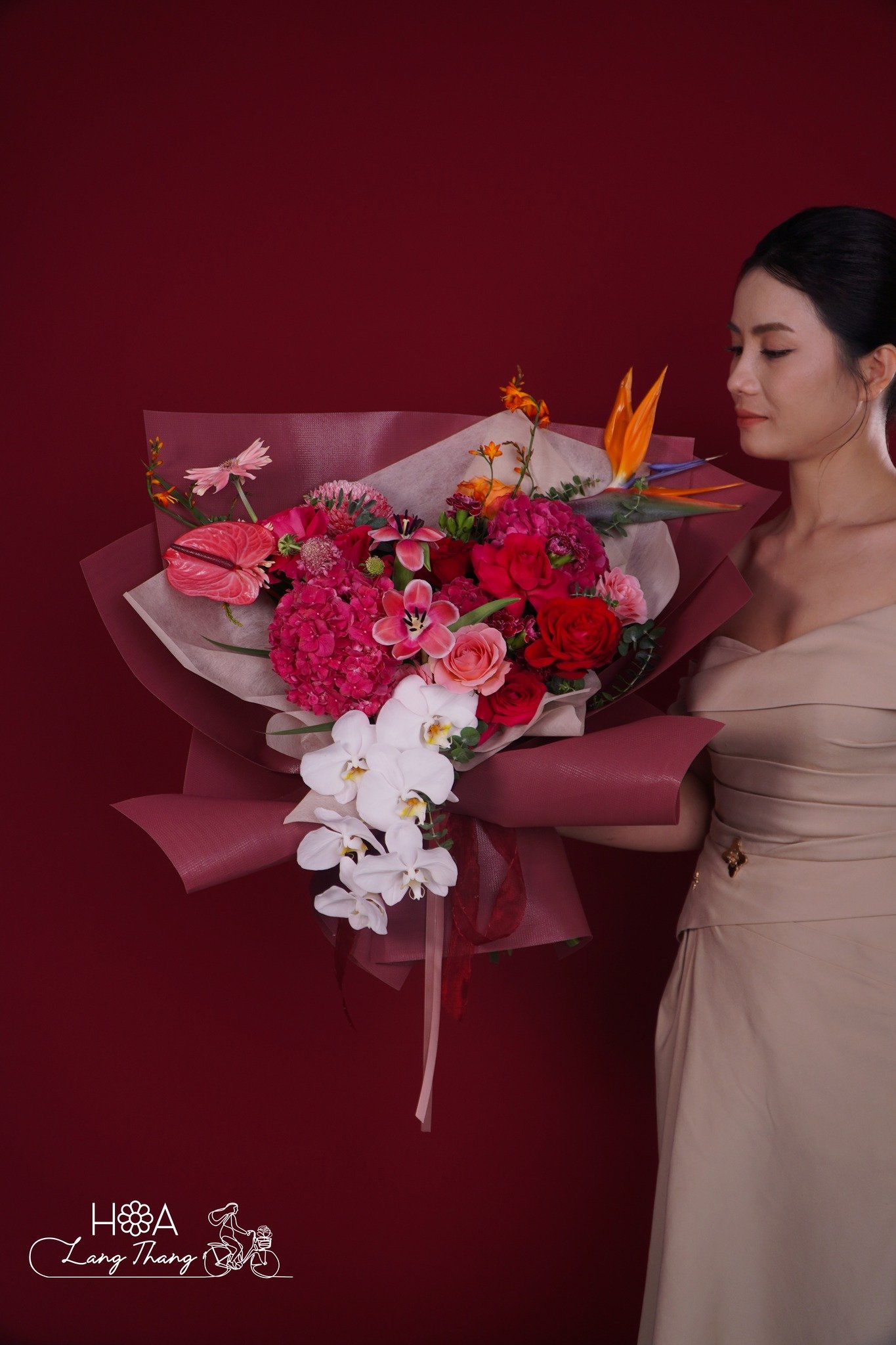 Bó hoa rực rỡ với nhiều loại hoa như hồng, lan hồ điệp, và cúc. Kiểu cắm sang trọng