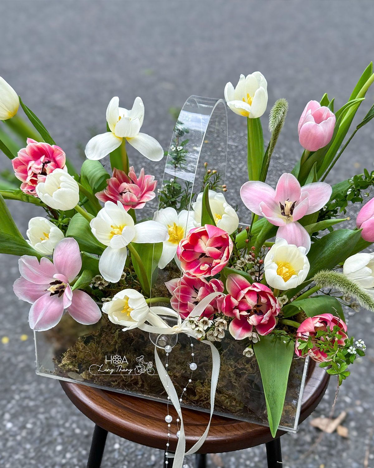 Bình hoa với tulip, hồng và thuyền tiên cắm đẹp mắt trong hộp trong suốt