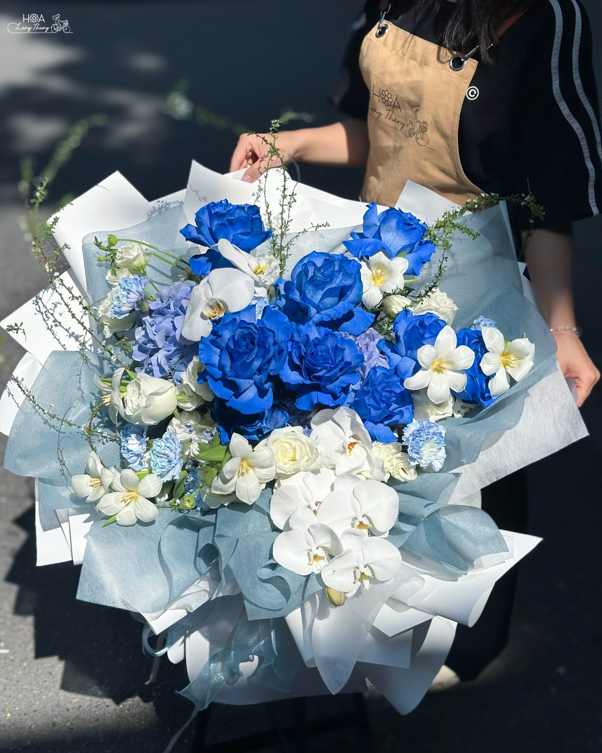 Bouquet hoa với hoa hồng xanh, lan hồ điệp trắng, kiểu cắm hiện đại