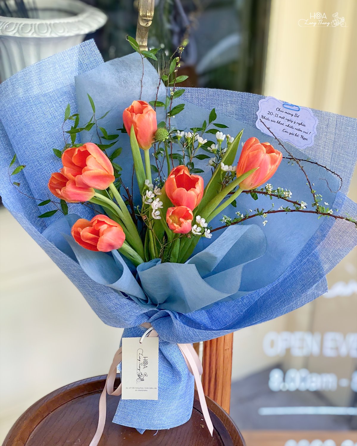 Bó hoa tulip cam nổi bật, trang trí sinh động với lá xanh và hoa baby