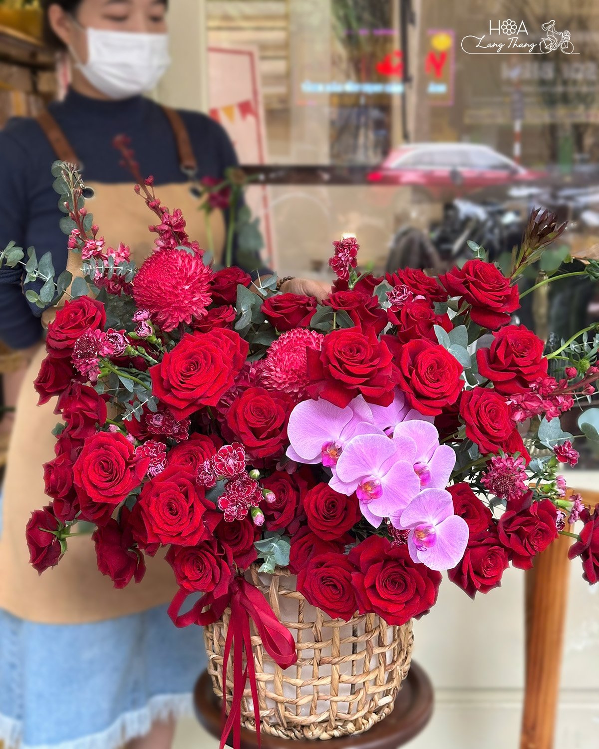 Một lẵng hoa vừa rực rỡ vừa đằm thắm với Red Naomi đỏ quyến rũ, cúc mẫu đơn bung nở đầy sức sống và lan hồ điệp nhẹ nhàng như