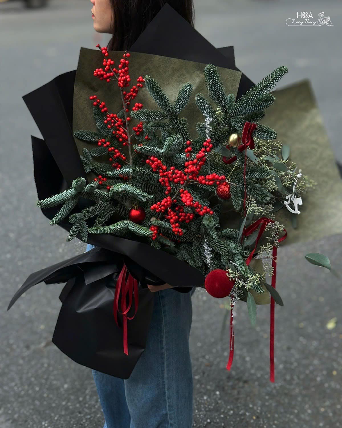 Bó hoa Noel đẹp với lá thông, quả chín đỏ, tạo không khí lễ hội