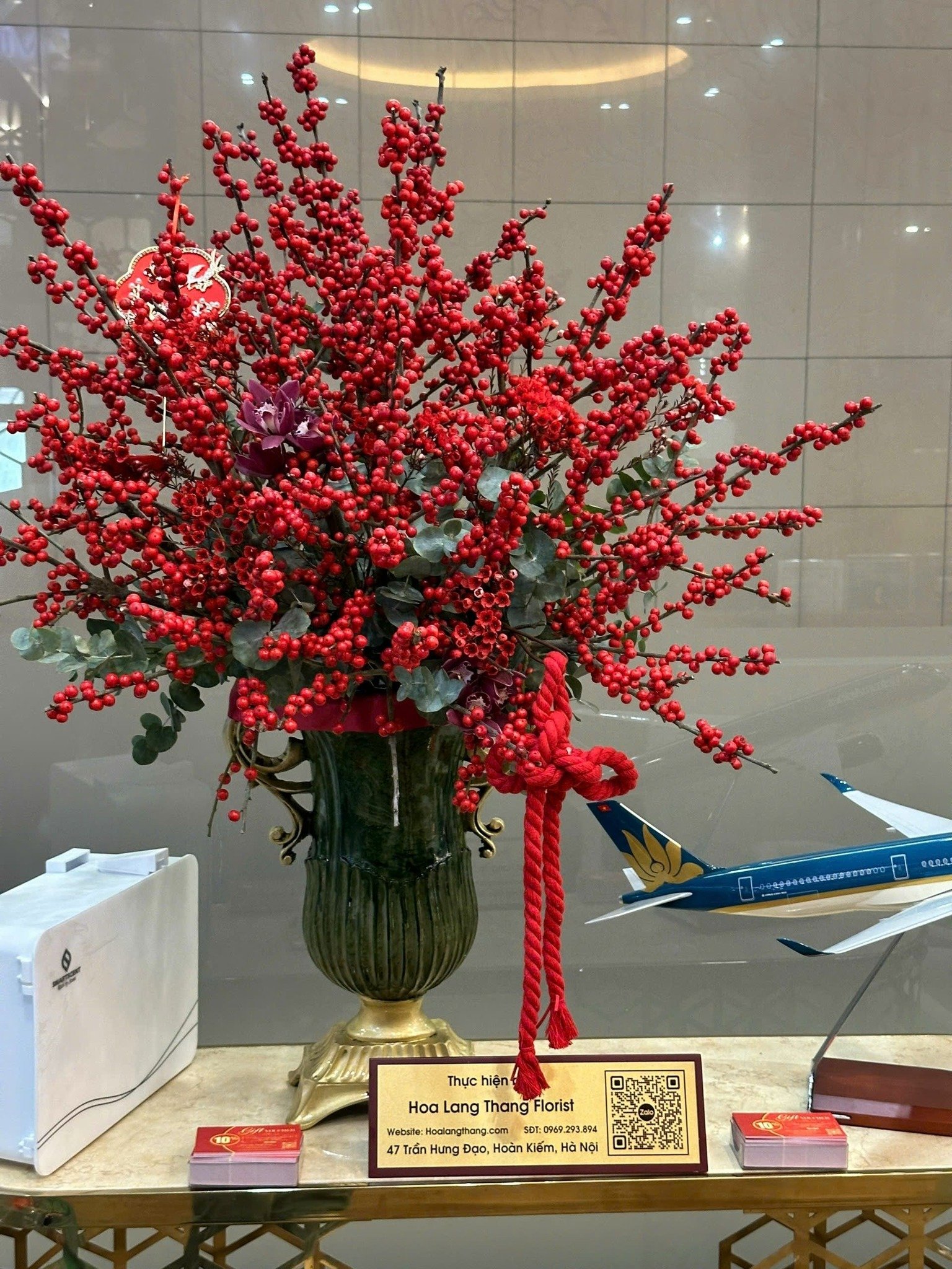 Bình hoa đỏ rực với nhánh berry, kiểu cắm sang trọng, thích hợp trang trí