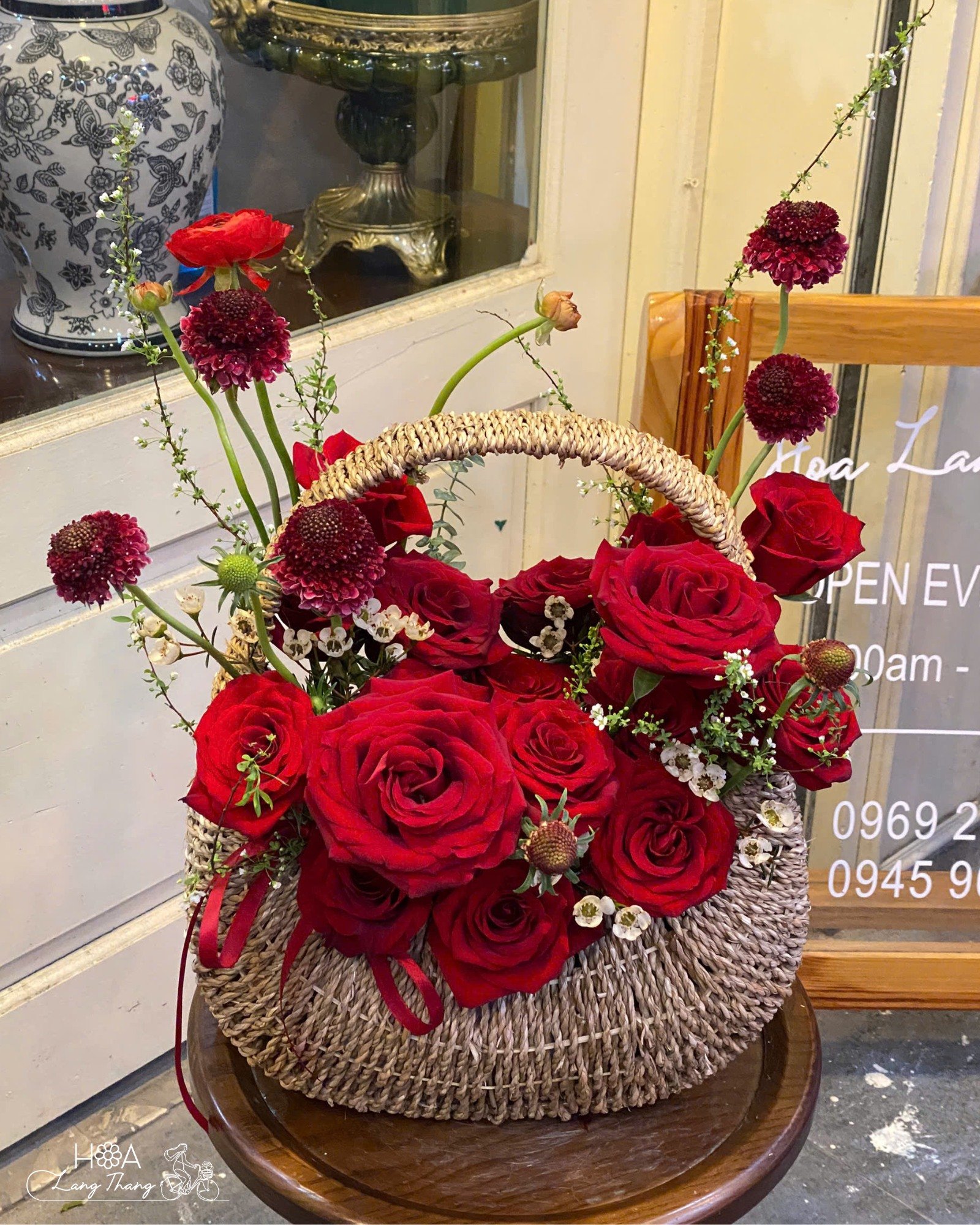 Giỏ hoa mang sắc đỏ quyến rũ từ Red Naomi kiêu sa, Scabiosa huyền bí và điểm xuyết thanh liễu tinh tế, tạo nên một thiết kế s