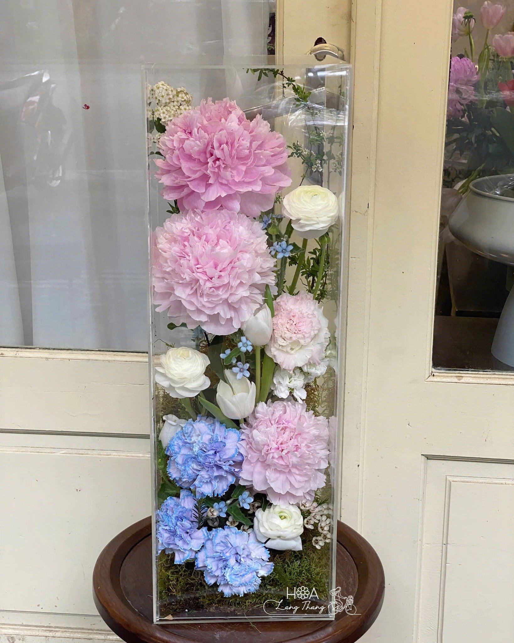 Bình hoa với hoa hồng, peony, và tulip tươi sáng trong khung kính