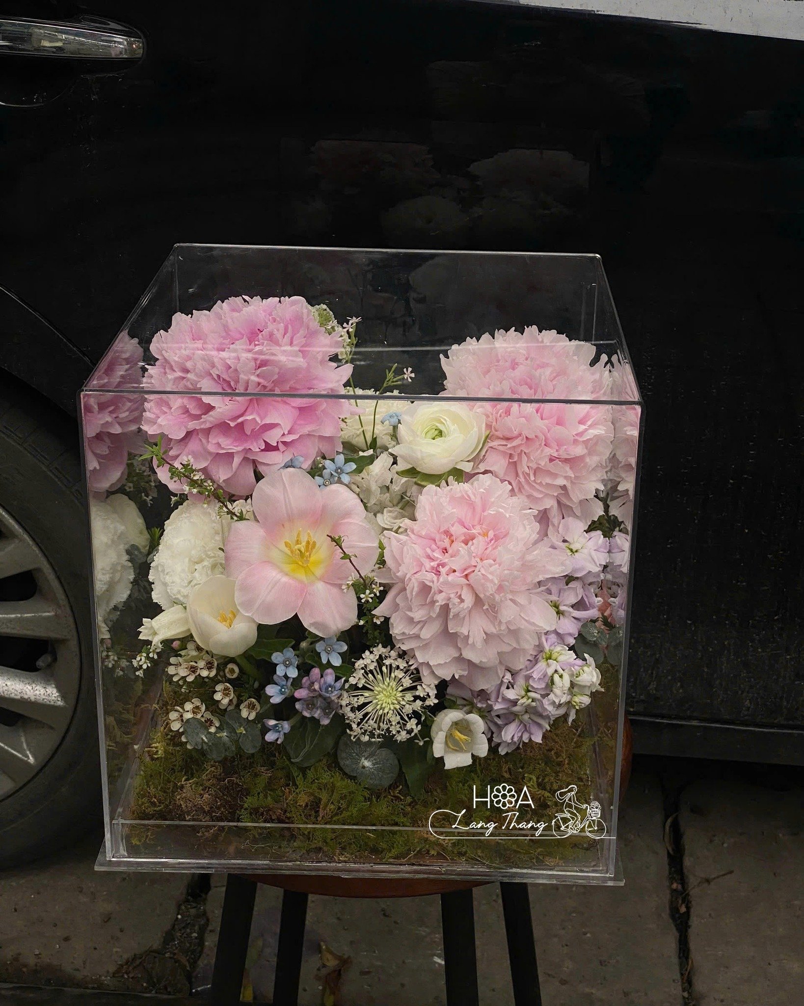 Bình hoa trong suốt với các loại hoa hồng, hoa mẫu đơn và hoa <a href=