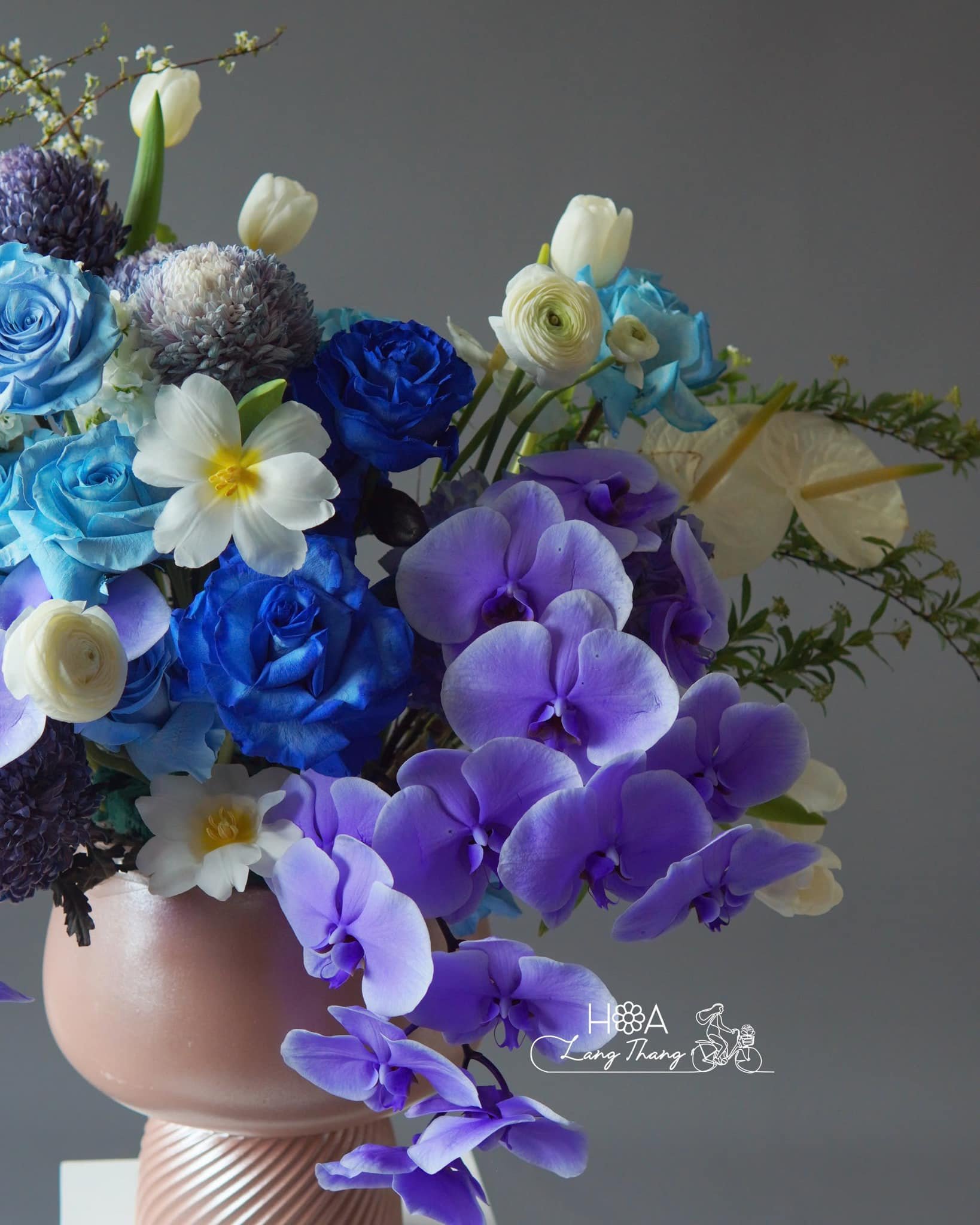 Bình hoa đẹp với hoa lan hồ điệp, hoa hồng, và hoa tulip màu xanh chủ đạo