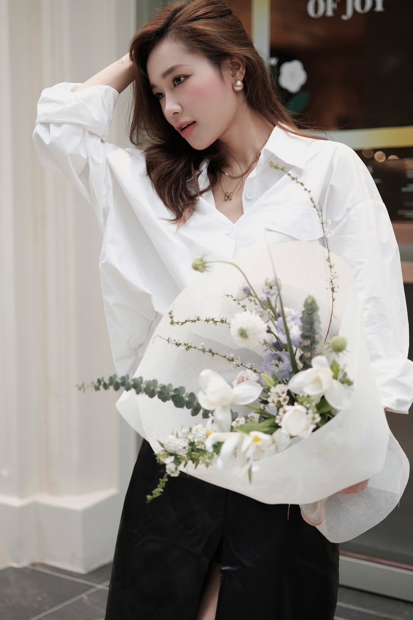 Cô gái cầm bó hoa tươi với tulip và baby, trang phục giản dị, đẹp thanh lịch