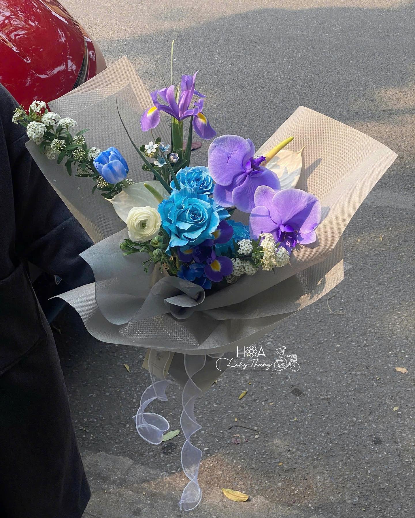 Bó hoa nhiều màu sắc gồm tulip, lan hồ điệp và hoa hồng xanh, kiểu cắm đẹp mắt