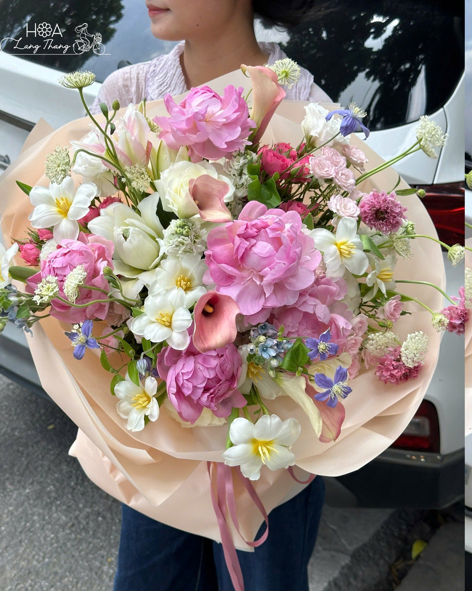 Bó hoa nhiều màu sắc, gồm hồng, tulip, và baby, cắm tự nhiên