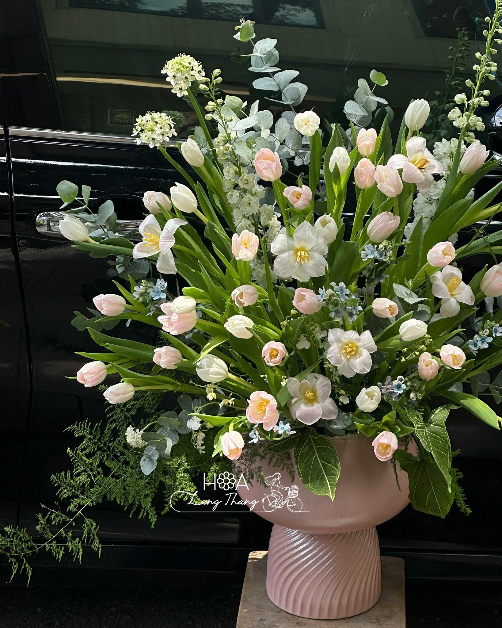 Bình hoa lớn với hoa tulip hồng và nhiều loại hoa khác, kiểu cắm tươi mát