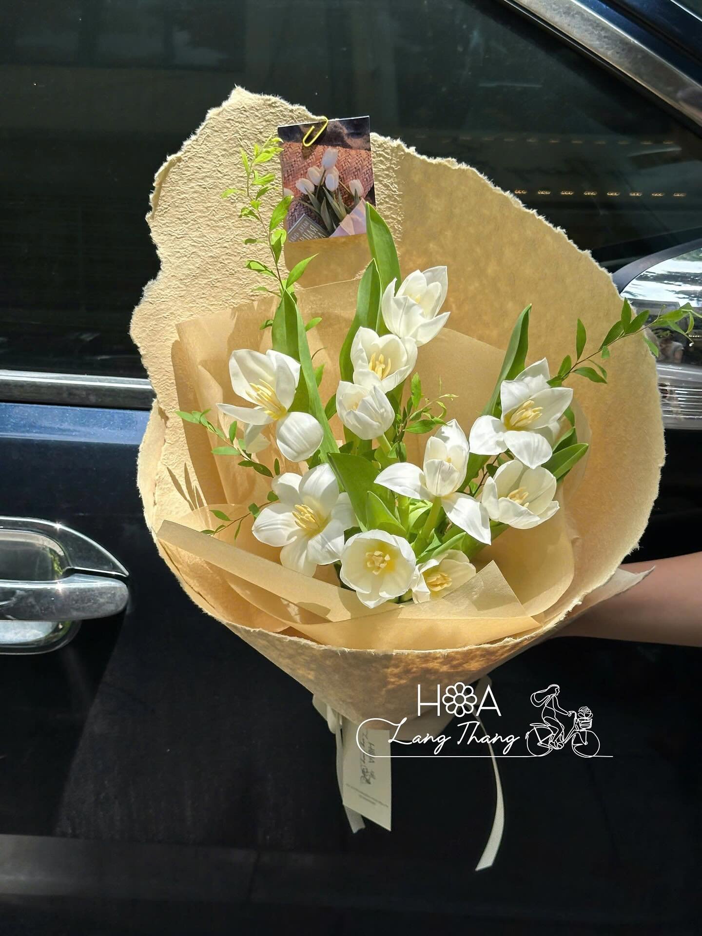 Bó hoa trắng với hoa lan hồ điệp và lá xanh, kiểu cắm thanh lịch