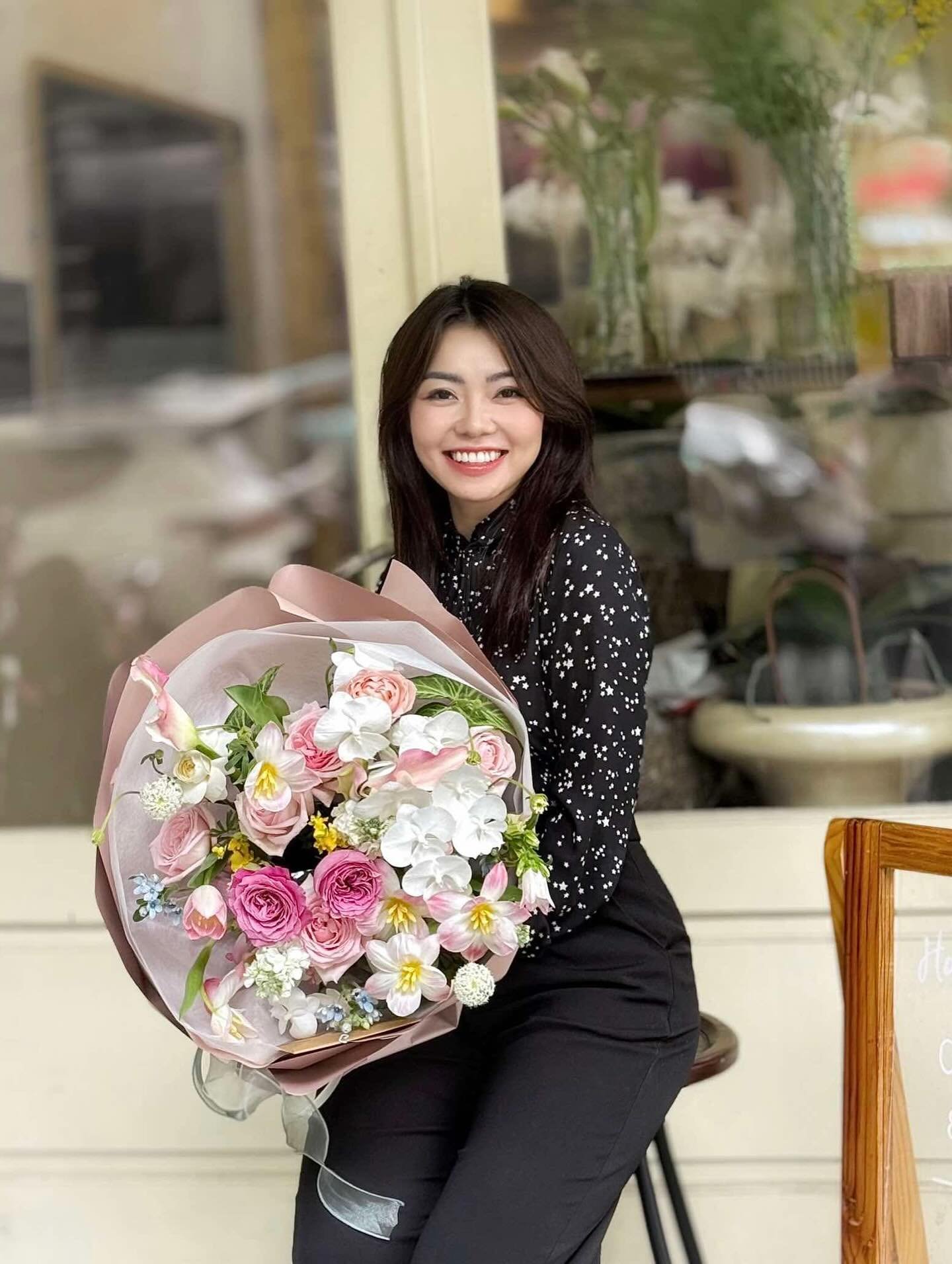 Cô gái cầm bó hoa nhiều màu sắc tươi sáng, phong cách cắm hiện đại