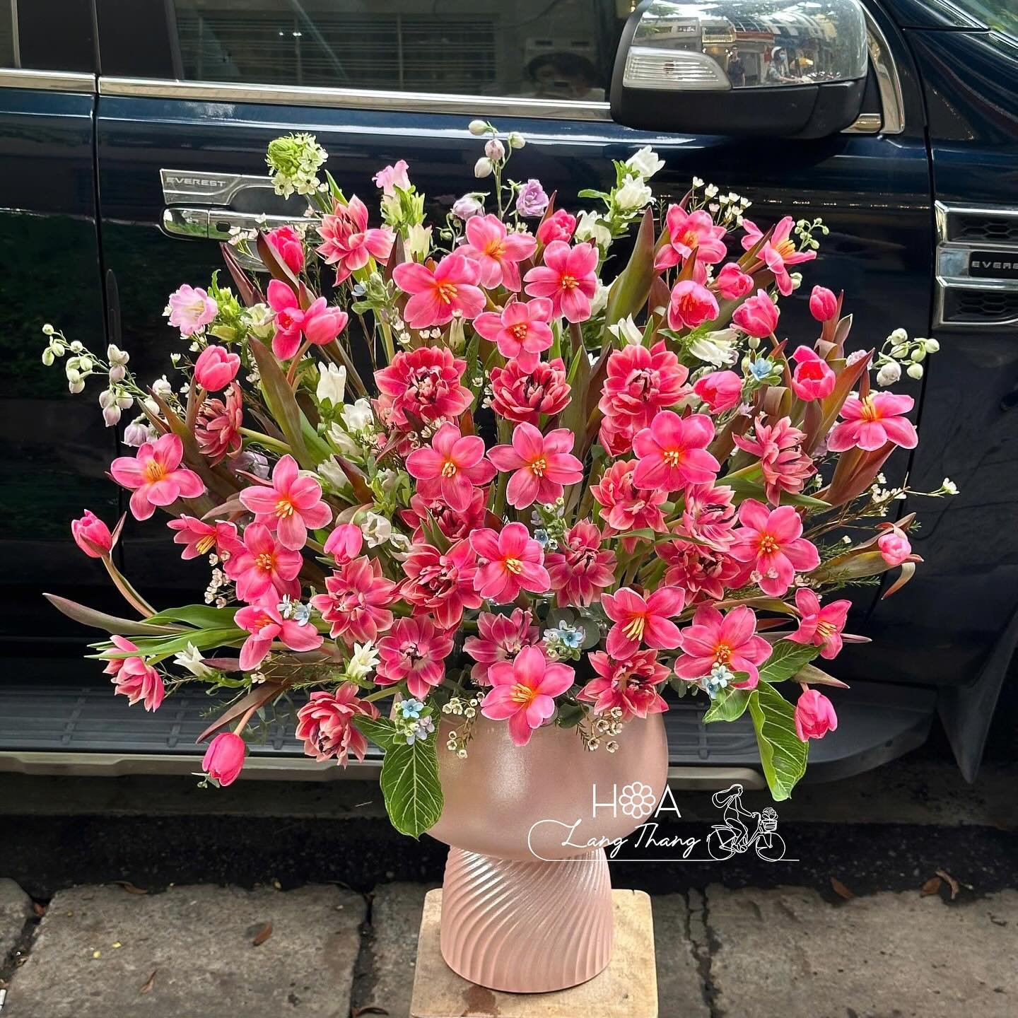 Bình hoa với nhiều hoa hồng và tulip, kiểu cắm hiện đại, màu sắc tươi tắn