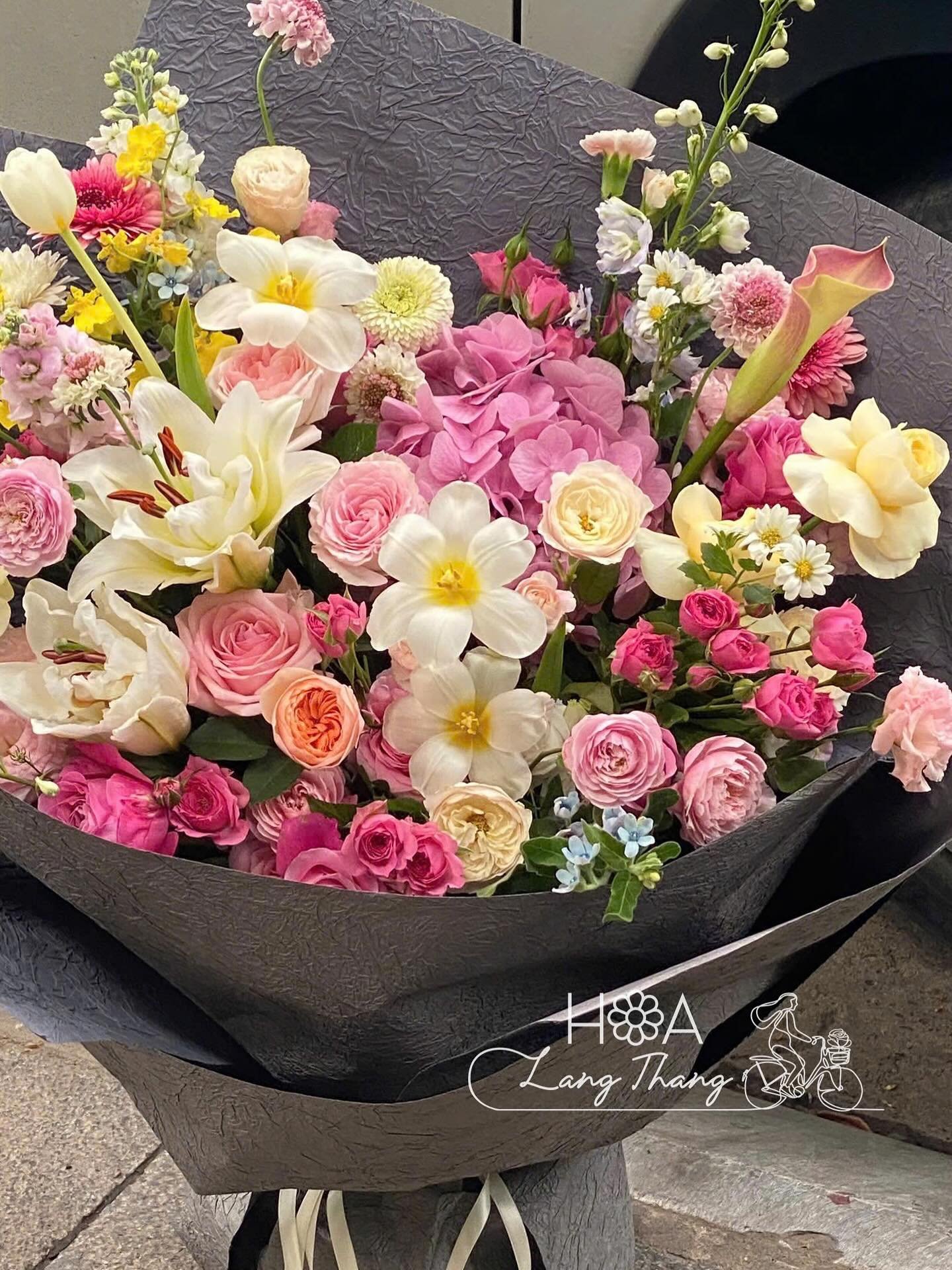 Bó hoa tươi đẹp với nhiều loại hoa như hồng, ly, và cát tường