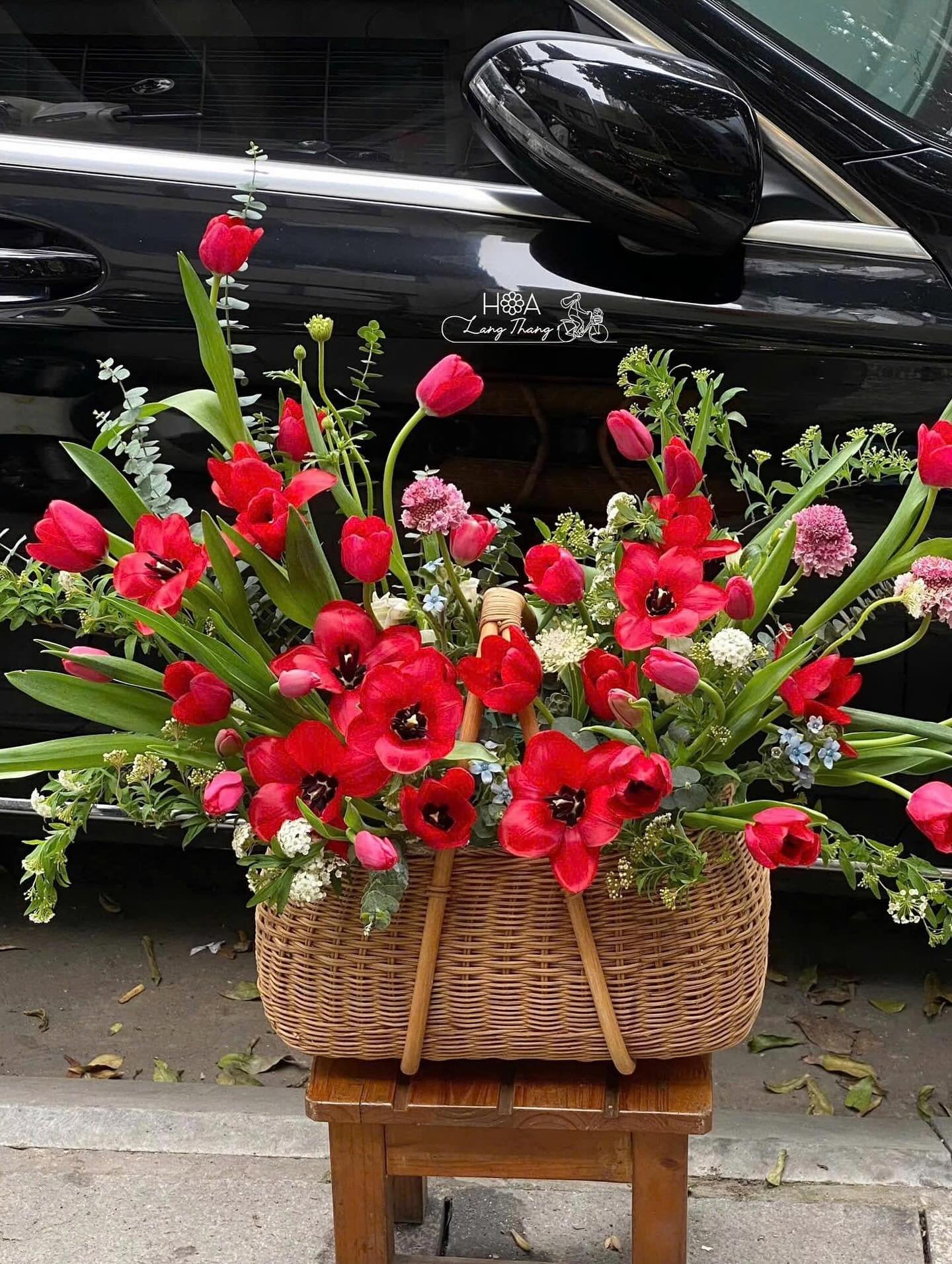 Chậu hoa tươi gồm tulip đỏ và nhiều loại hoa nhỏ xung quanh, cắm đẹp mắt
