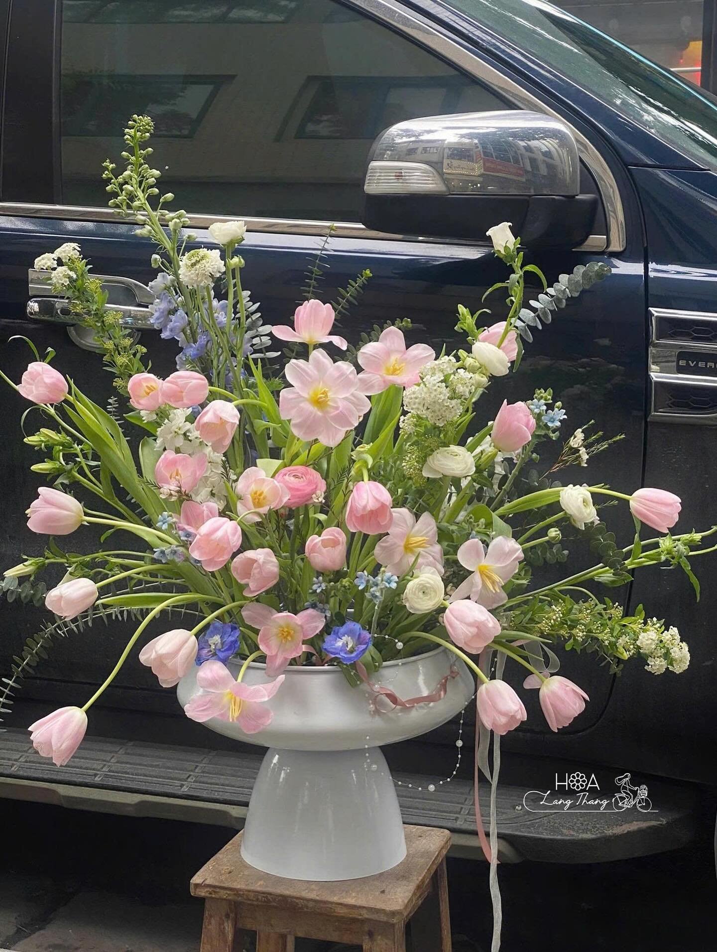 Bình hoa với tulip hồng, hoa baby trắng và lan hồ điệp, kiểu cắm lãng mạn