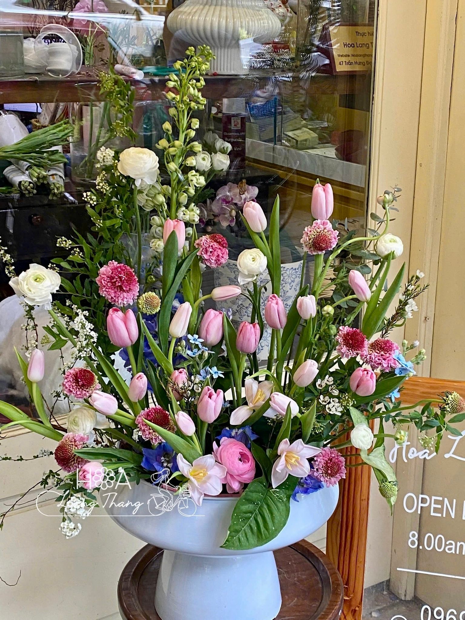 Bình hoa đa sắc với tulip, hồng và cúc đang nở rộ, tạo không gian tươi vui