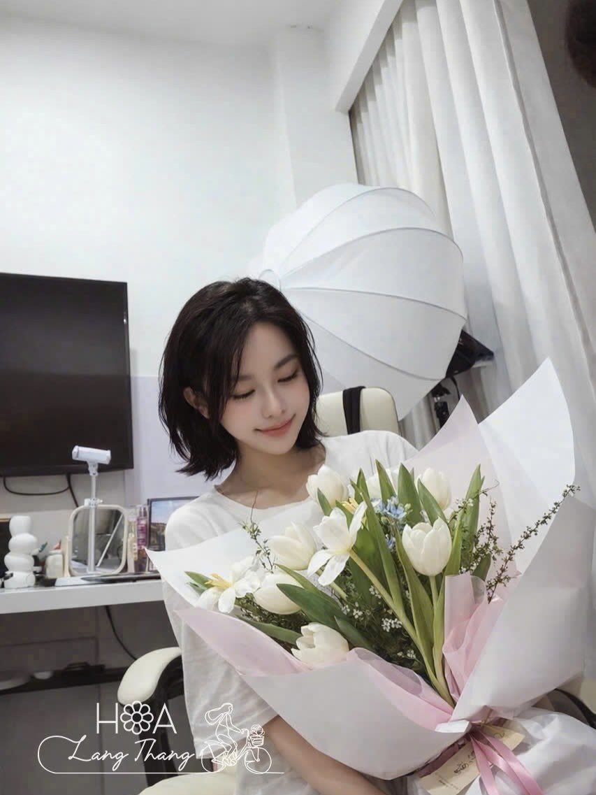 Cô gái cầm bó hoa tulip trắng và xanh trong không gian giản dị