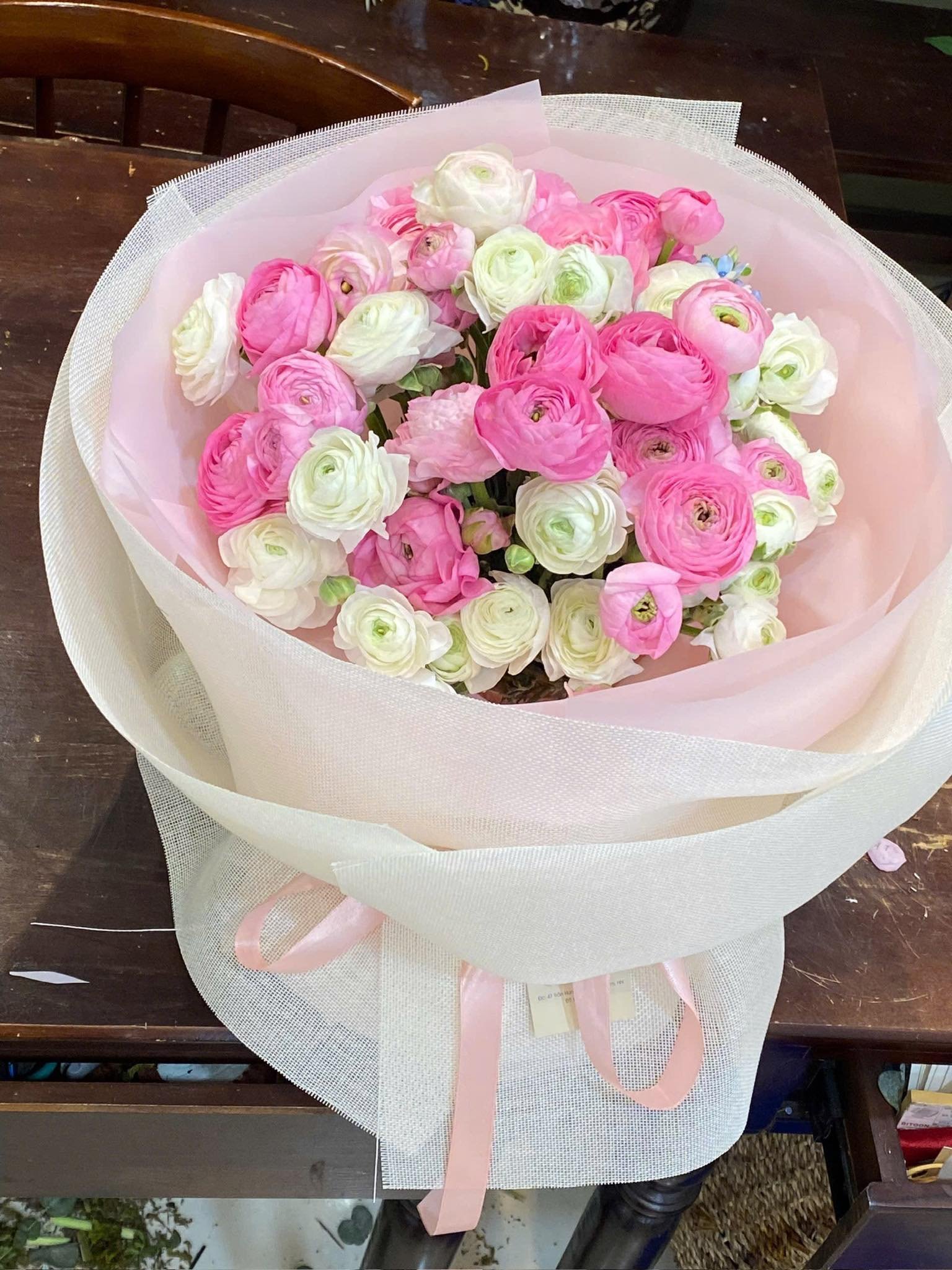 Bó hoa gồm hoa ranunculus hồng, trắng được cắm tinh tế