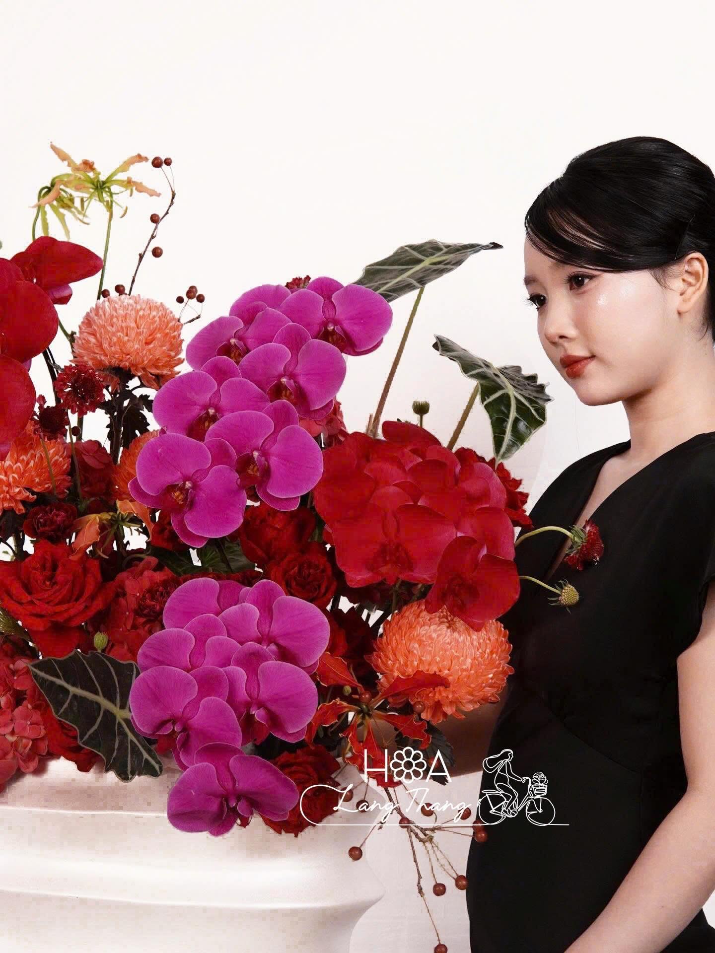 Người phụ nữ bên hoa <a href=