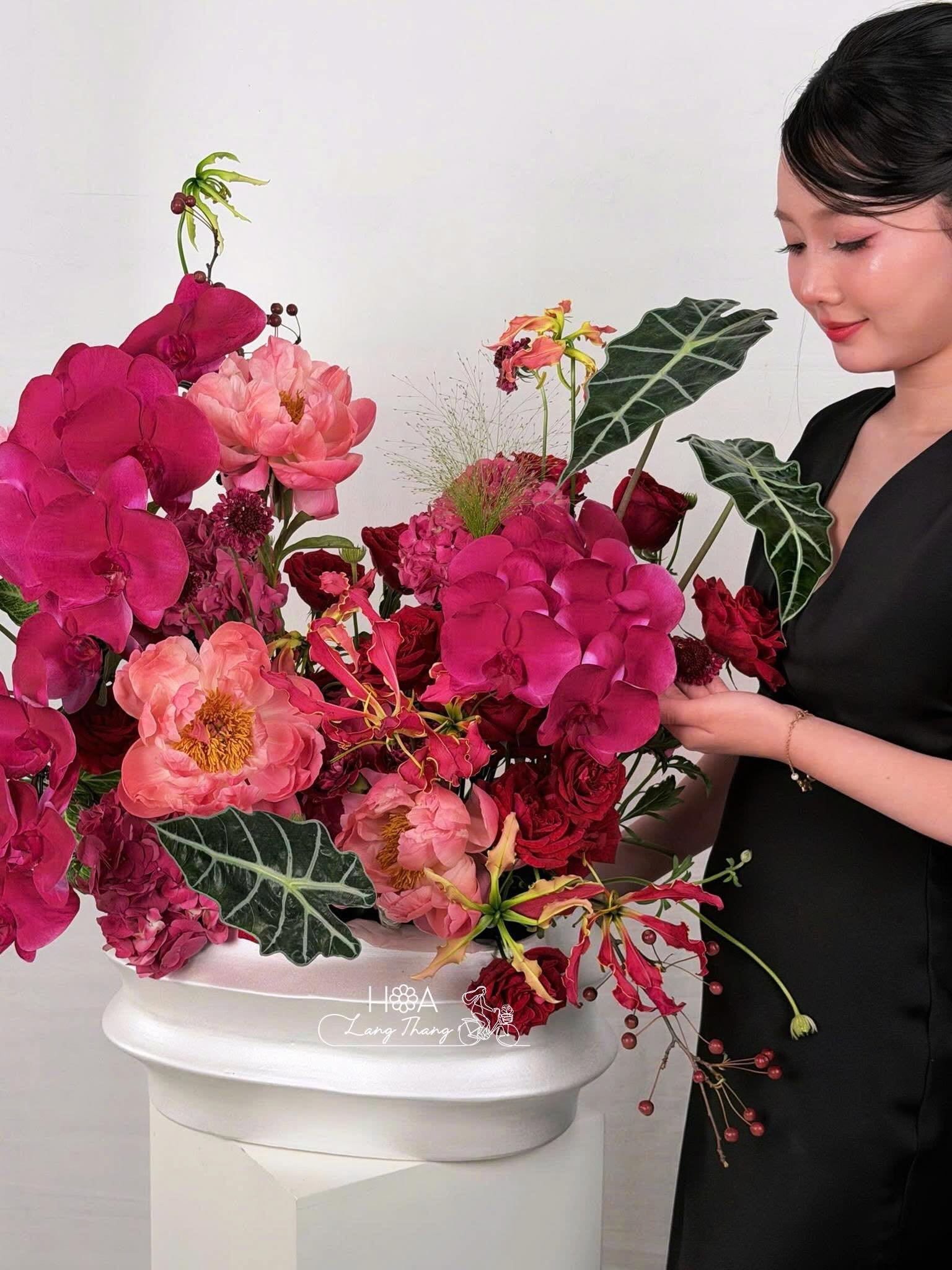 Cắm hoa tinh tế với hoa hồng, mẫu đơn và lan hồ điệp, mang sắc đỏ và hồng tươi sáng